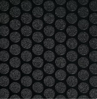 Close-up of raised coin pattern PVC garage flooring roll being installed, slip-resistant black surface